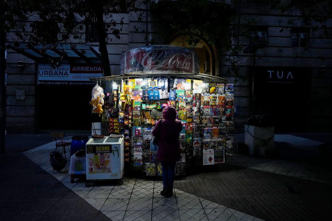 A customer wearing a puffer jacket stands in front of a kiosk in Santiago, Chile, Friday, May 17, 2024.