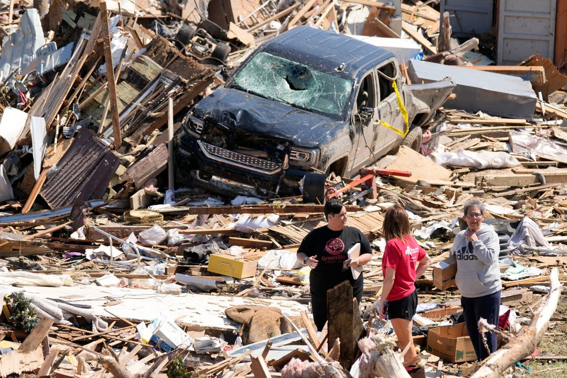 People survey debris from tornado damaged homes in Greenfield, Iowa on Wednesday.