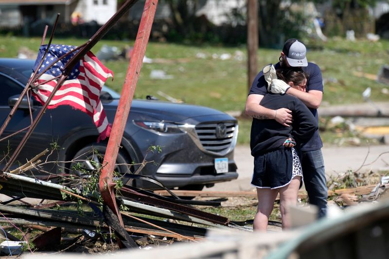 Greenfield residents hug in front of their tornado damaged home on Wednesday in Iowa.