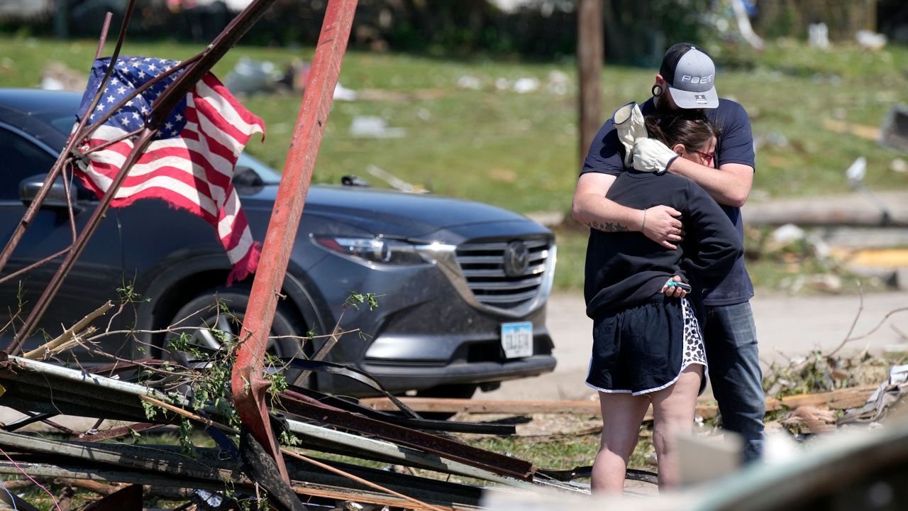 Greenfield residents hug in front of their tornado damaged home on Wednesday in Iowa.