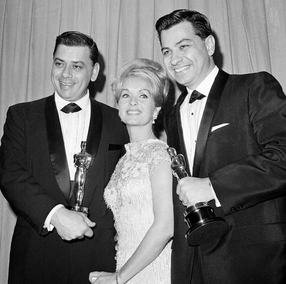 Actress Debbie Reynolds poses with Academy Awards winners for best music Richard M. Sherman, right, and Robert Sherman, left, who received the award for 