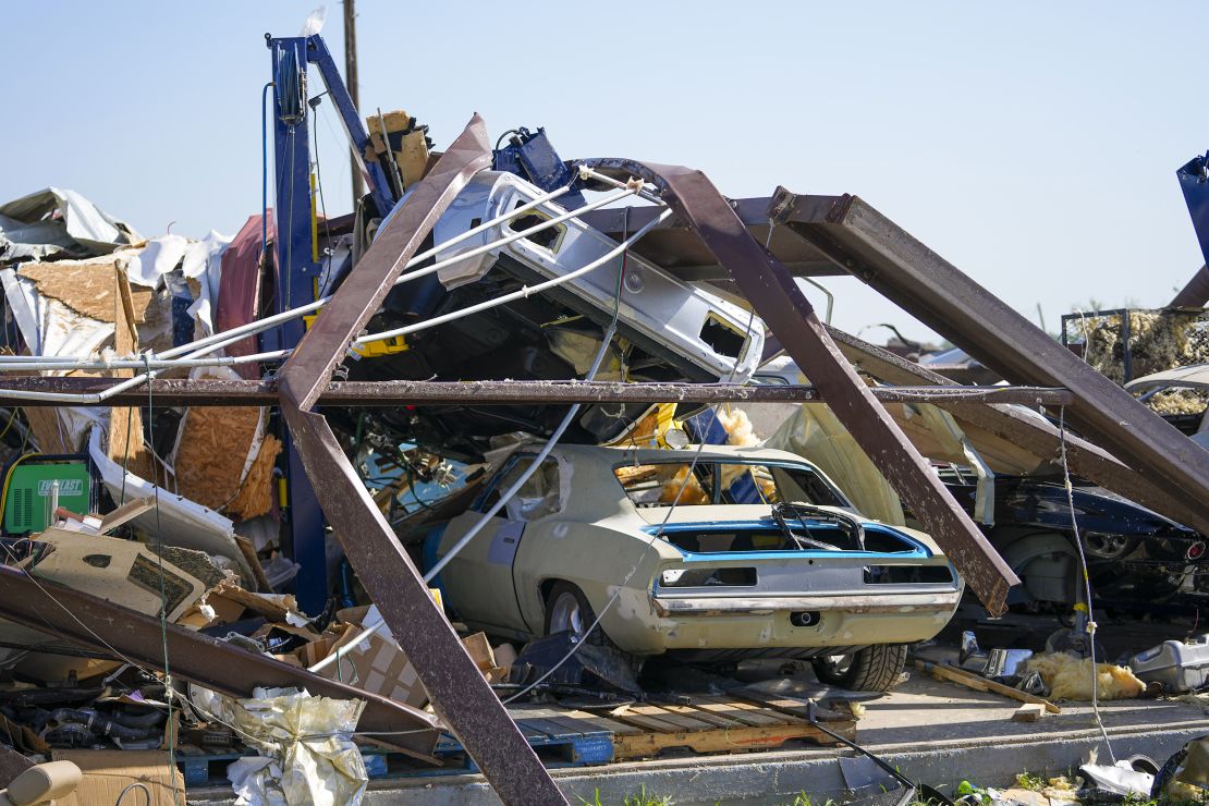 Vehicles in a body shop are seen amid debris the morning after a tornado rolled through in Valley View, Texas.