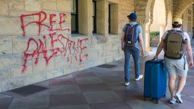 Students walk by graffiti near Stanford University President Richard Saller's office in Palo Alto, California, on Wednesday, June 5, 2024.