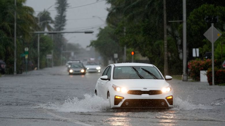 Cars drive through flooded streets on Tuesday in Surfside, Florida.