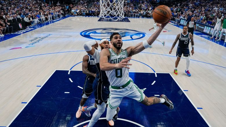 Boston Celtics forward Jayson Tatum (0) goes up for a basket in front of Dallas Mavericks forward P.J. Washington during the first half in Game 3 of the NBA basketball finals, Wednesday, June 12, 2024, in Dallas. The Celtics won 106-99. (AP Photo/Julio Cortez, Pool)
