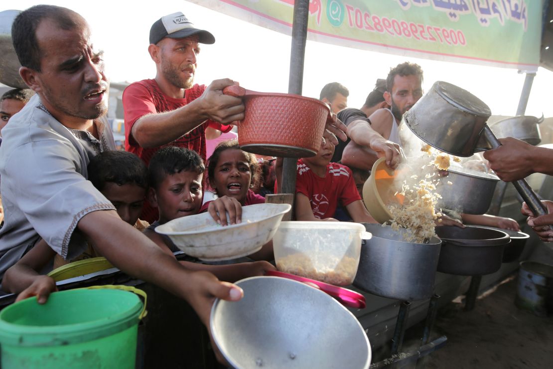 Palestinians collect food aid ahead of the upcoming Eid al-Adha holiday in Khan Younis, Gaza, on June 15, 2024.