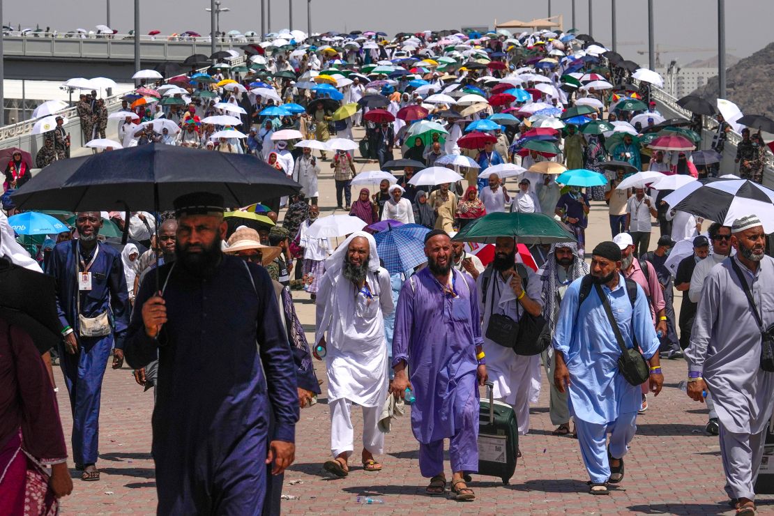 Muslim pilgrims use umbrellas to protect themselves from the sun.