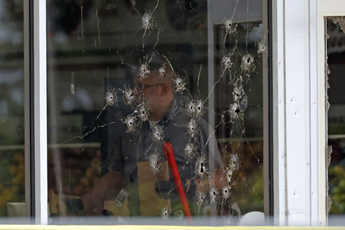 Damage can be seen to a front window as law enforcement officers work the scene of a shooting at the Mad Butcher grocery store in Fordyce, Ark., Friday, June 21, 2024.