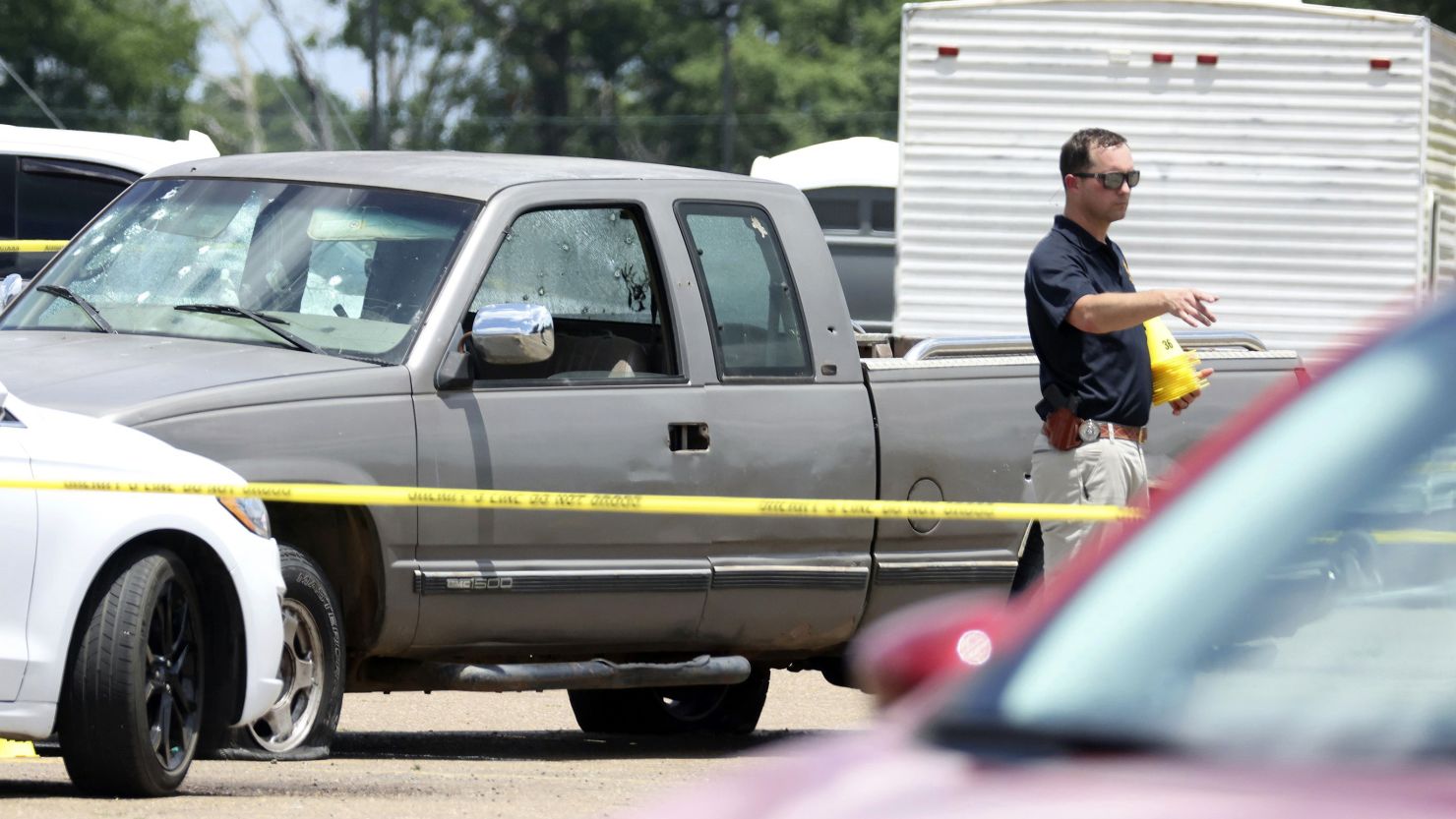 Law enforcement officers work the scene of the shooting Friday at Mad Butcher grocery store in Fordyce, Arkansas.