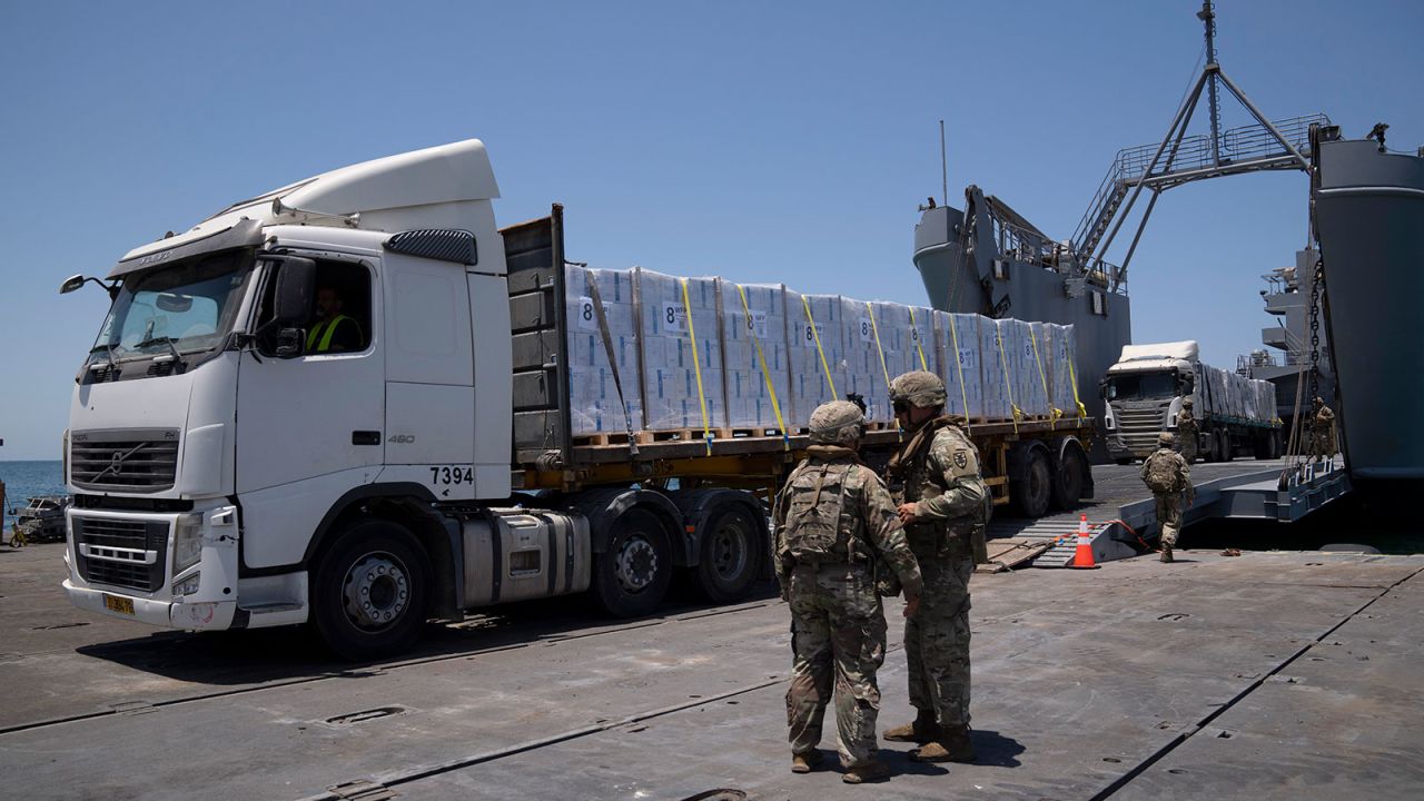 U.S. Army soldiers stand next to trucks arriving loaded with humanitarian aid at the U.S.-built floating pier Trident before reaching the beach on the coast of the Gaza Strip, Tuesday, June 25, 2024. (AP Photo/Leo Correa)
