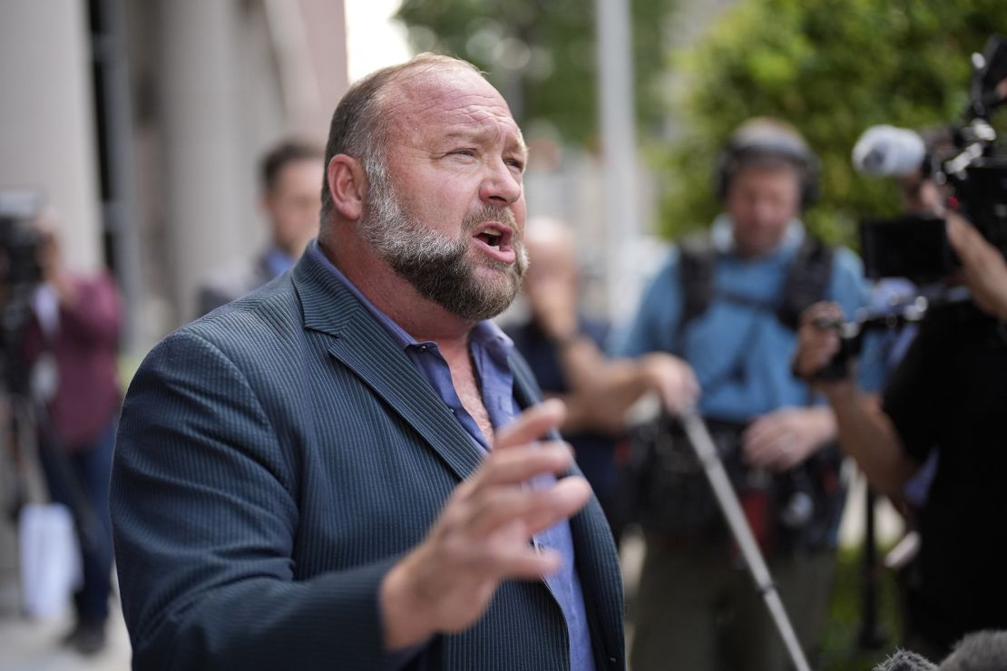 Alex Jones speaks to the media after arriving at the federal courthouse for a hearing in front of a bankruptcy judge, Friday, June 14, 2024, in Houston. The right-wing conspiracy theorist's media outlet Infowars was auctioned off to pay off settlements to the families of the victims of the Sandy Hook mass shooting.