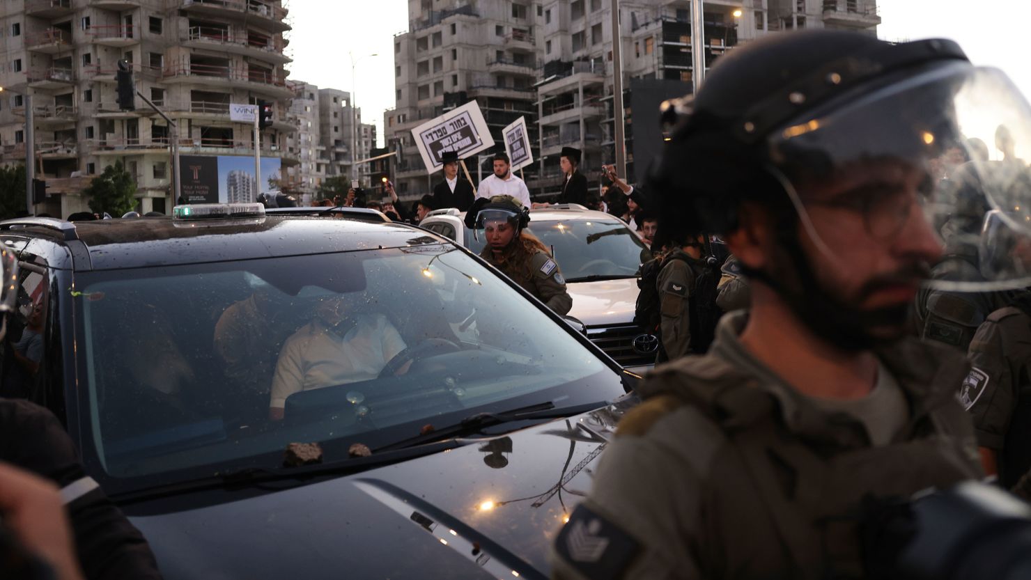 Security forces square off with ultra-Orthodox demonstrators as they attack the car of Yitzhak Goldknopf, Israel's housing minister, during a protest against the IDF draft on June 30.