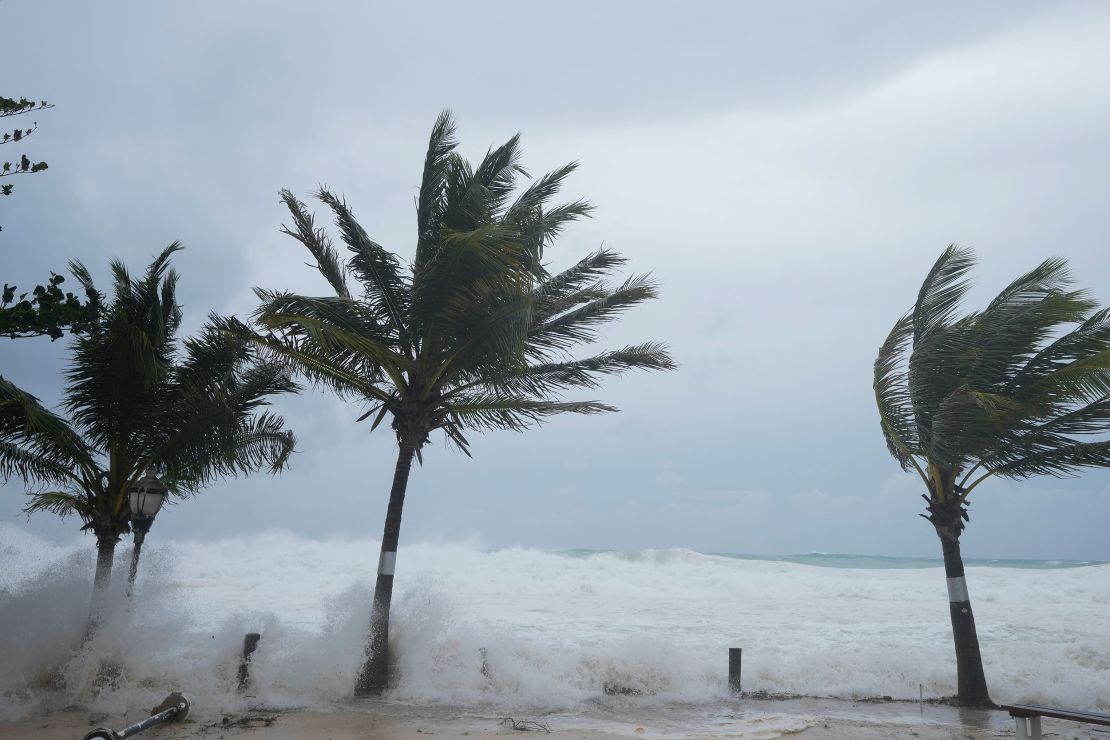Lunedì le onde hanno colpito le palme durante l'impatto dell'uragano Beryl su Hastings, Barbados.