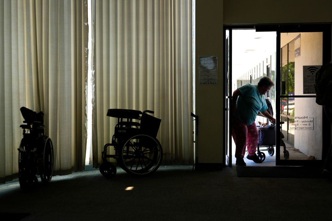 Sherri Thompson, with her chihuahua 14-year-old Kiwahi, arrives at the Cook Plaza cooling center on Friday, in Gresham, Oregon.