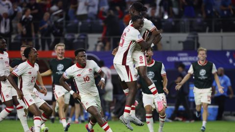 Canada midfielder Ismaël Koné celebrates with his teammates after making the winning penalty kick.