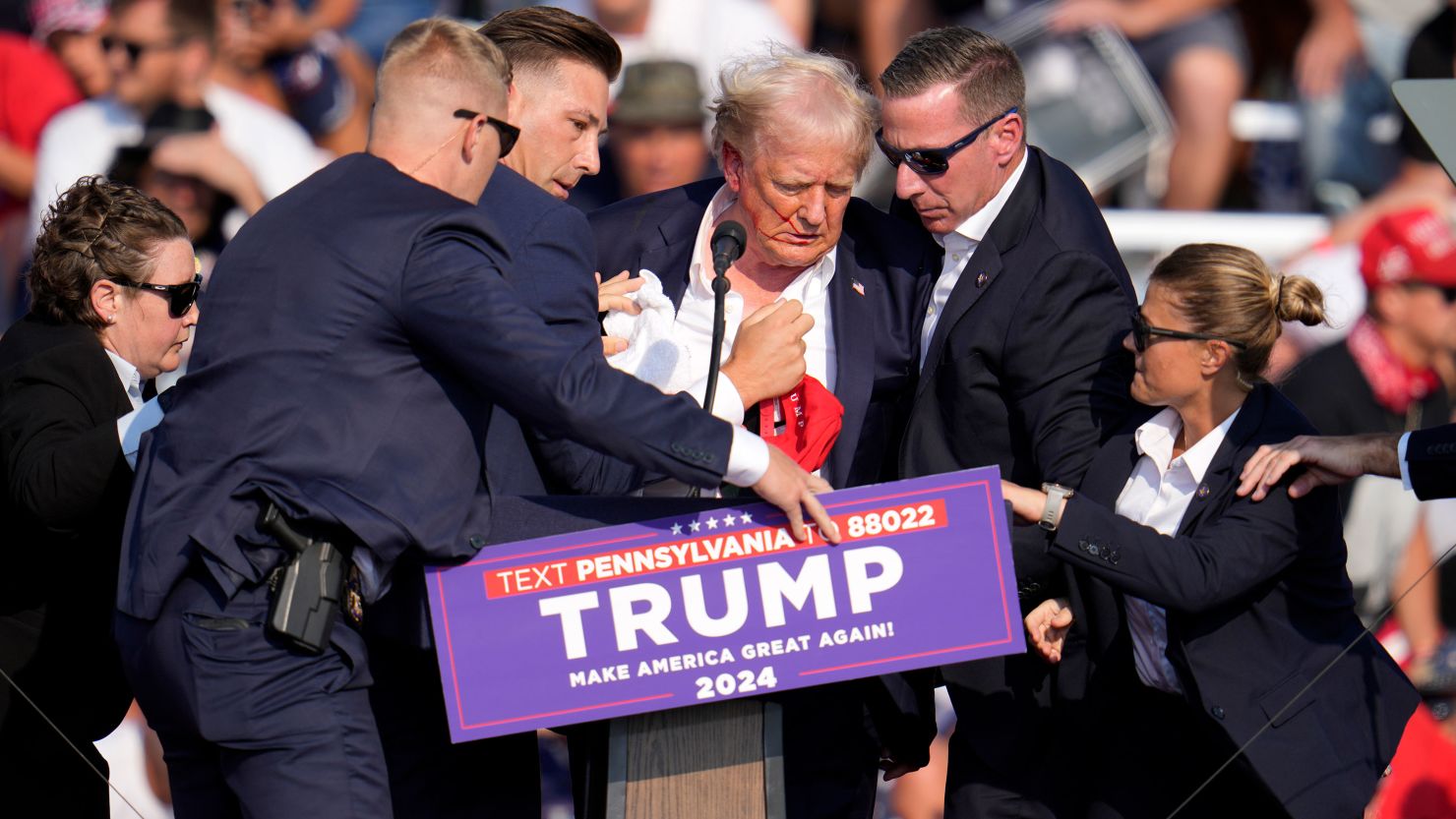 Former President Donald Trump is helped off the stage at a campaign event in Butler, Pennsylvania, on July 13, 2024. (AP Photo/Gene J. Puskar)