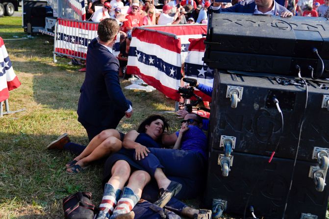 People take cover at the rally.