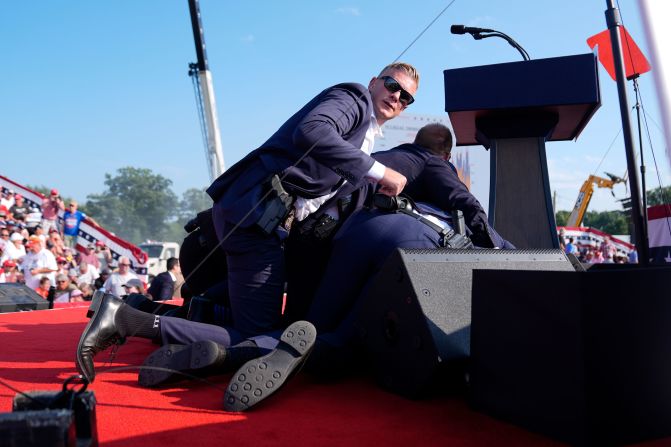 Secret Service agents cover the former president.