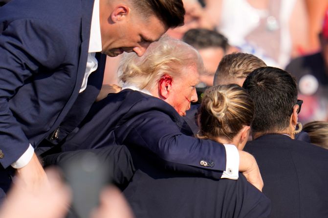 Blood is seen on Trump's right ear as he is helped off the stage.