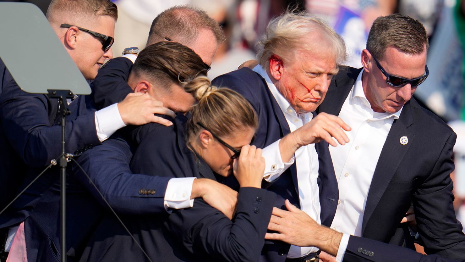 Former President Donald Trump is helped off the stage by US Secret Service agents at a campaign event in Butler, Pennsylvania, on July 13, 2024.