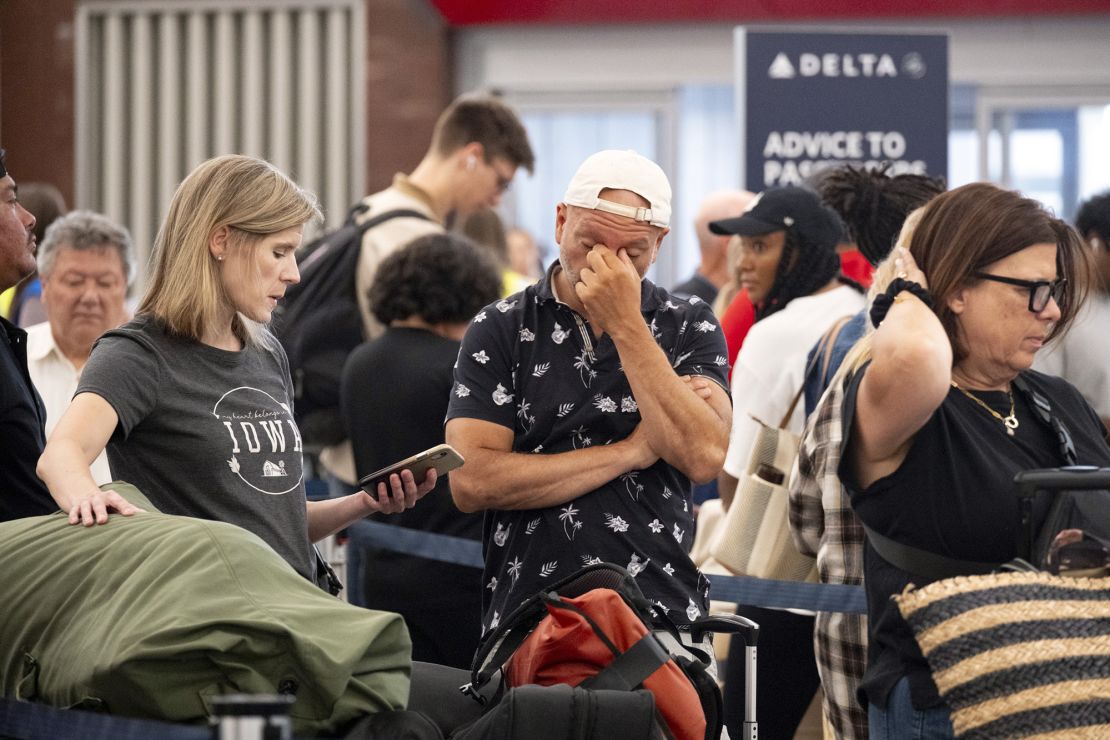 Tiffany McAllister and Andres Bernal try to rebook their flight to Iowa while stuck at Hartsfield-Jackson Atlanta International Airport on Friday.