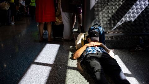 A passenger takes a nap inside a terminal at Harry Reid International Airport on Friday, July 19, 2024, after a faulty CrowdStrike update caused a major internet outage for computers running Microsoft Windows. (AP Photo/Ty ONeil)