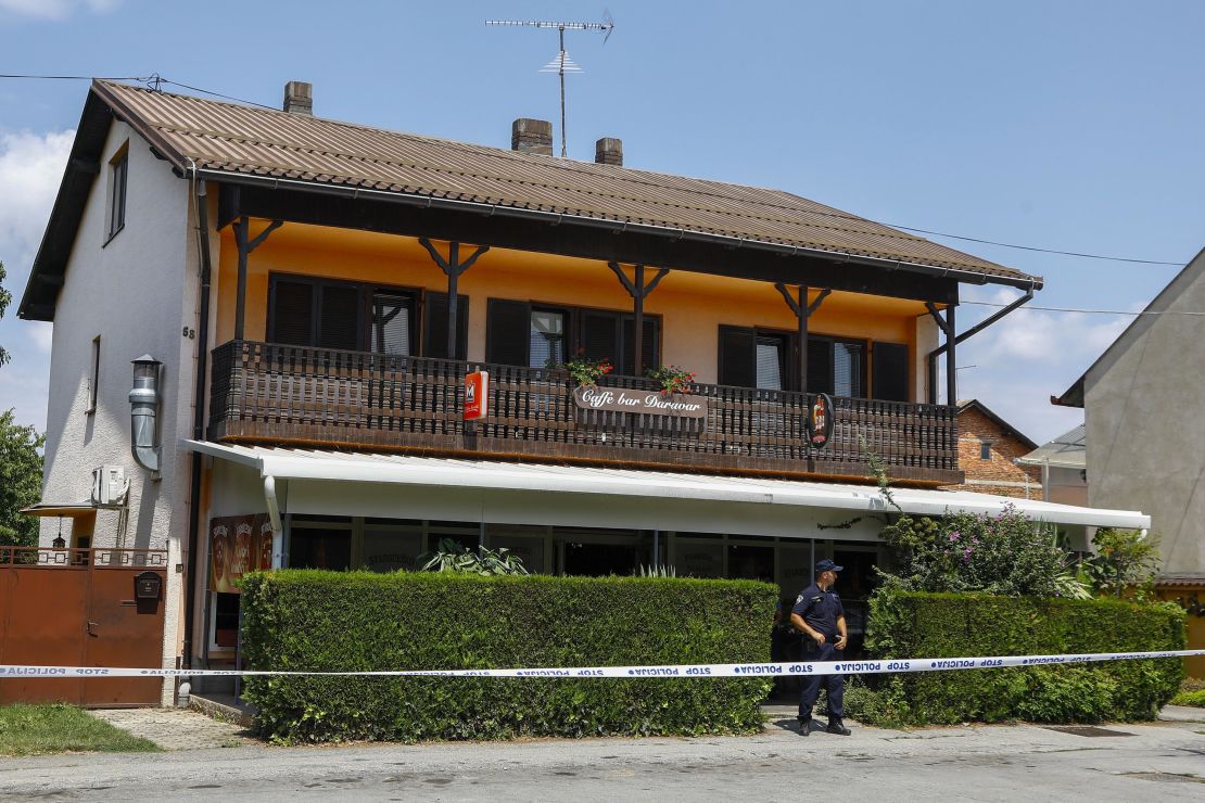 A police officer stands outside the cafe where the shooter was arrested.