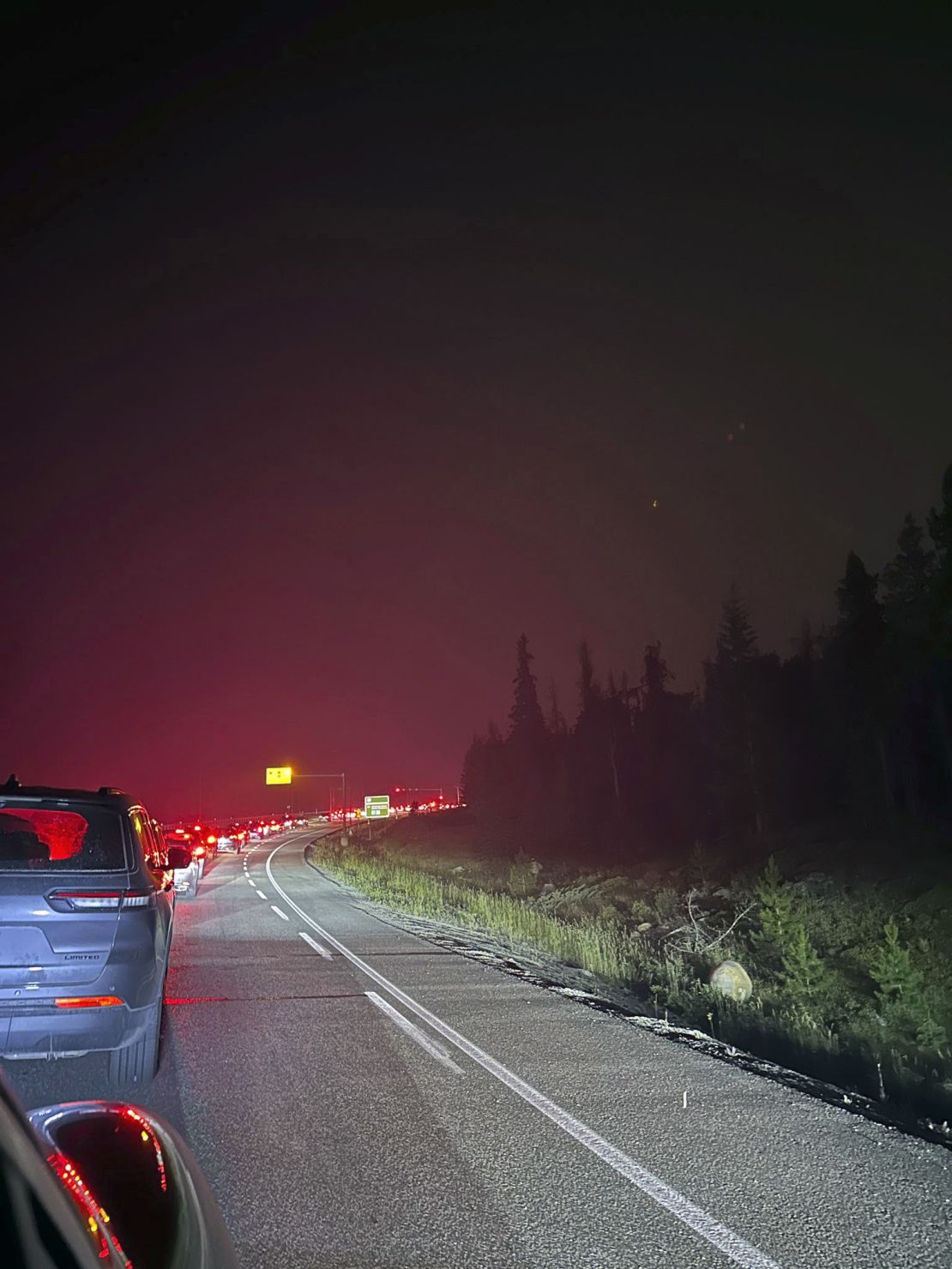 This photo provided by Carolyn Campbell shows cars clogging the highway as people evacuate because of wildfires early Tuesday in Jasper, Alberta.