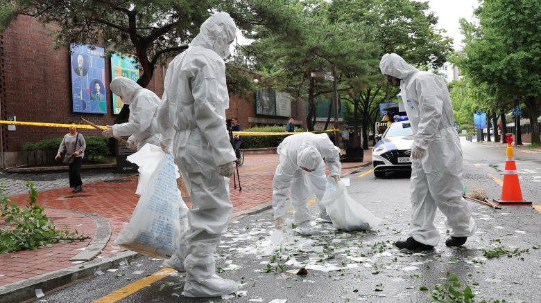 Officers wearing protective gear collect the trash from a balloon presumably sent by North Korea, on July 24, 2024, in Seoul, South Korea.