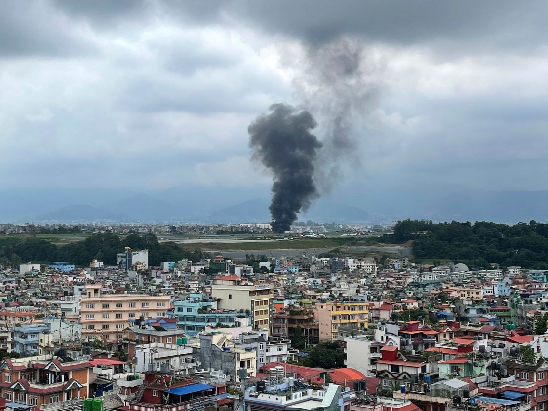 Smoke rises from the Tribhuvan International Airport in Kathmandu, Nepal. State television says a plane slipped off the runway and crashed while trying to take off from the airport.