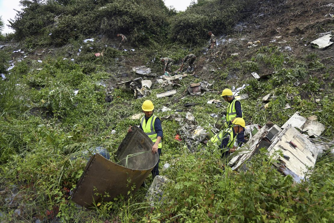 Rescue workers search the plane crash site at Tribhuvan International Airport.