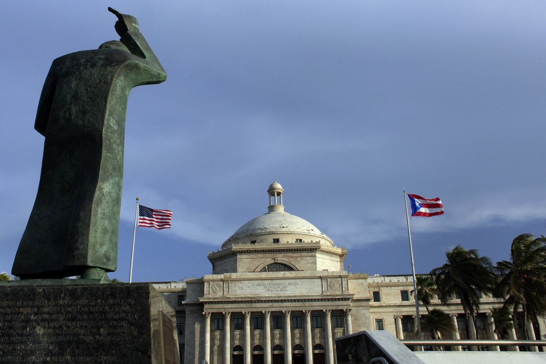 A bronze statue of San Juan Bautista stands in front the Capitol building flanked by U.S. and Puerto Rican flags, in San Juan, Puerto Rico, where a ruling was made on Wednesday to ban hair discrimination.