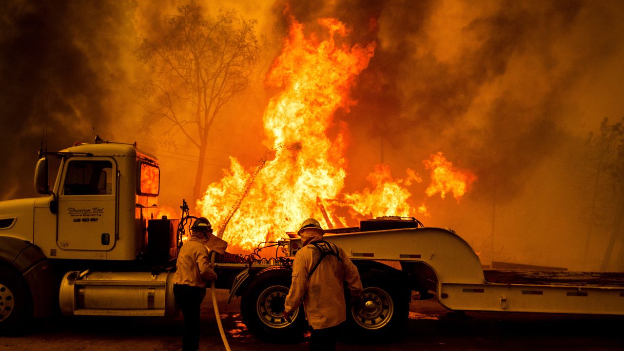 Firefighters spray water as the Park Fire tears though the Cohasset community in Butte County, California, on July 25, 2024.