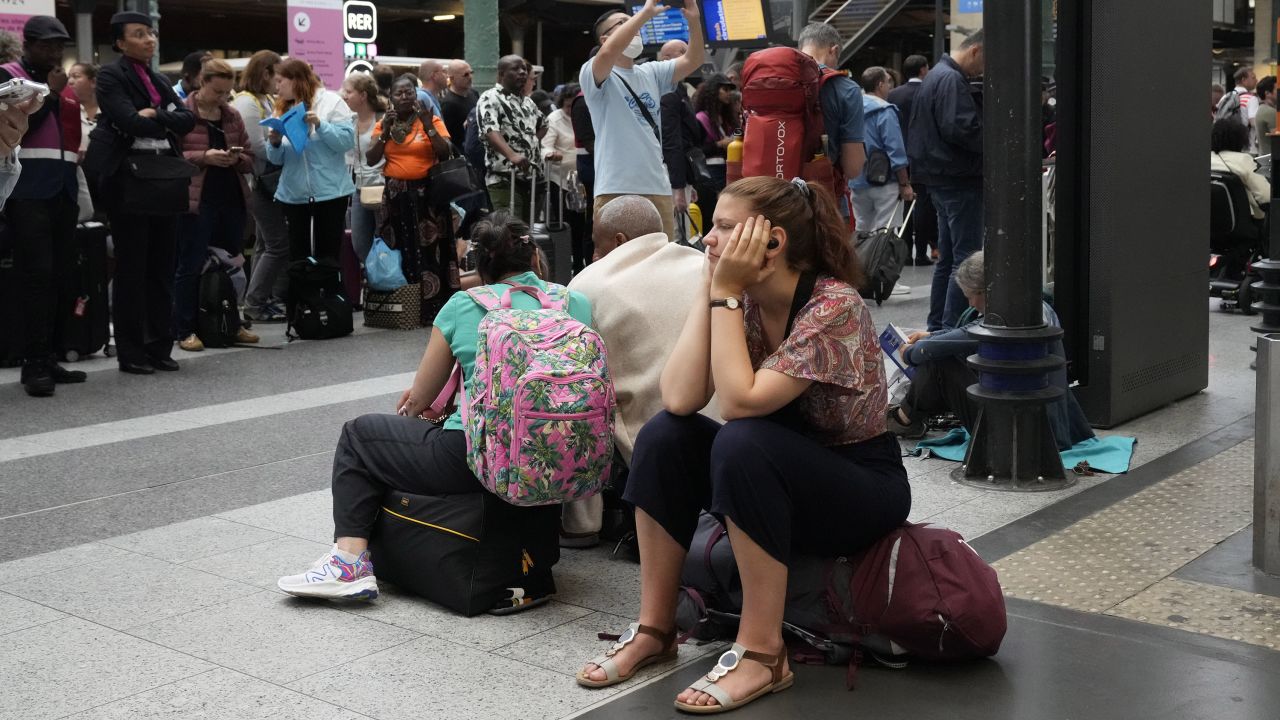 A traveler waits inside the Gare du Nord train station at the 2024 Summer Olympics, Friday, July 26, 2024, in Paris, France. Hours away from the grand opening ceremony of the Olympics, high-speed rail traffic to the French capital was severely disrupted on Friday by what officials described as "criminal actions" and sabotage. (AP Photo/Mark Baker)