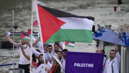 Palestinian flag bearers Wasim Abusal and Valerie Rose Tarazi travel with teammates along the Seine River in Paris, France, during the opening ceremony of the 2024 Summer Olympics, Friday, July 26, 2024. (AP Photo/Kirsty Wigglesworth)