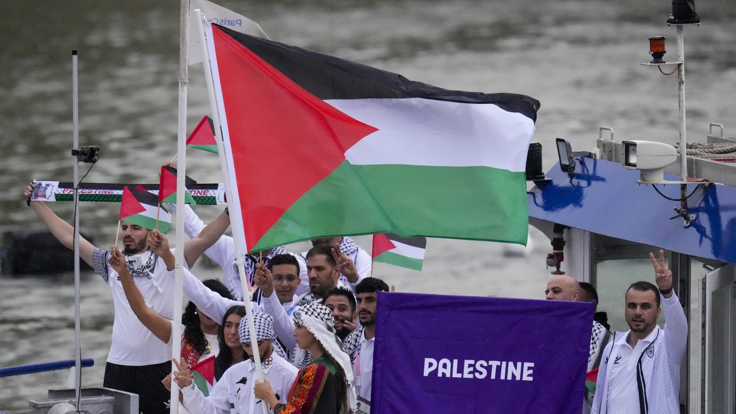 Palestinian flag bearers Wasim Abusal and Valerie Rose Tarazi travel with teammates along the Seine River in Paris, France, during the opening ceremony of the 2024 Summer Olympics.