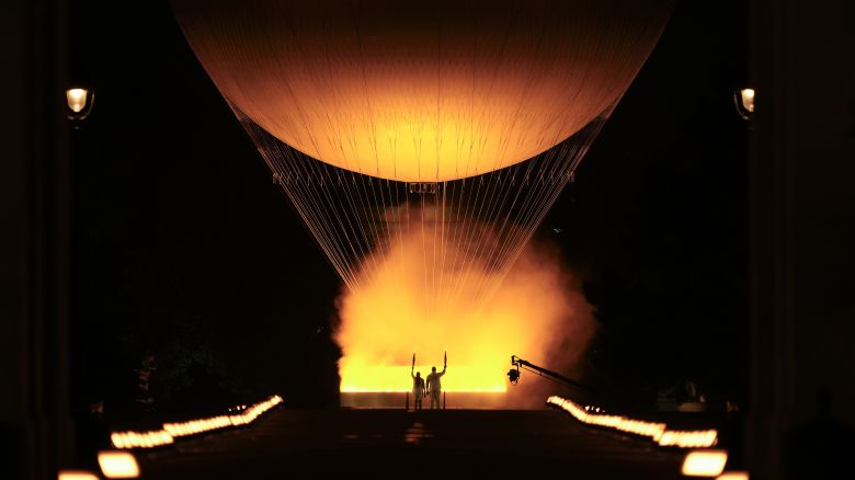 Teddy Riner and Marie-Jose Perec watch as the cauldron rises in a balloon in Paris, France, during the opening ceremony of the 2024 Summer Olympics, Friday, July 26, 2024. (AP Photo/Vadim Ghirda)
