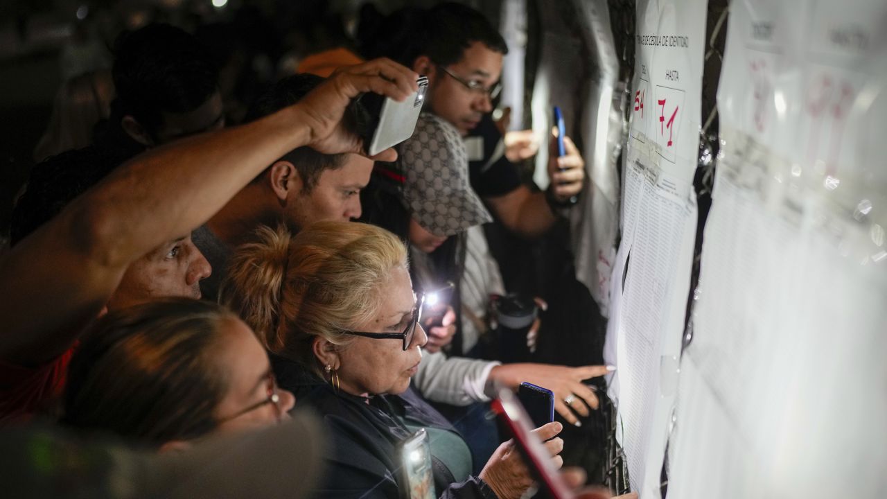 Voters look at electoral lists prior to the opening of the polls for presidential elections in Caracas, Venezuela, Sunday, July 28, 2024.