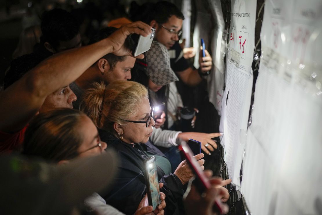 Voters look at electoral lists prior to the opening of the polls for presidential elections in Caracas, Venezuela, Sunday, July 28, 2024.