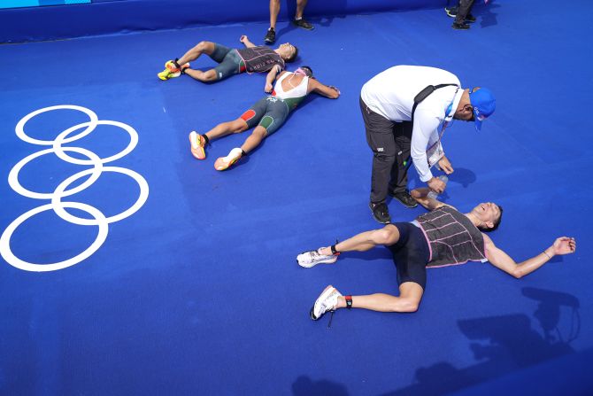 Exhausted triathletes catch their breath at the end of the competition on July 31.