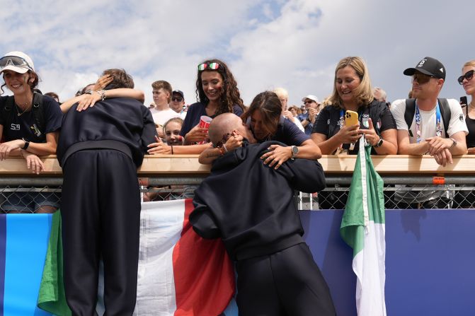 Italian rower Luca Rambaldi, center, celebrates after winning silver in the quadruple sculls on July 31.