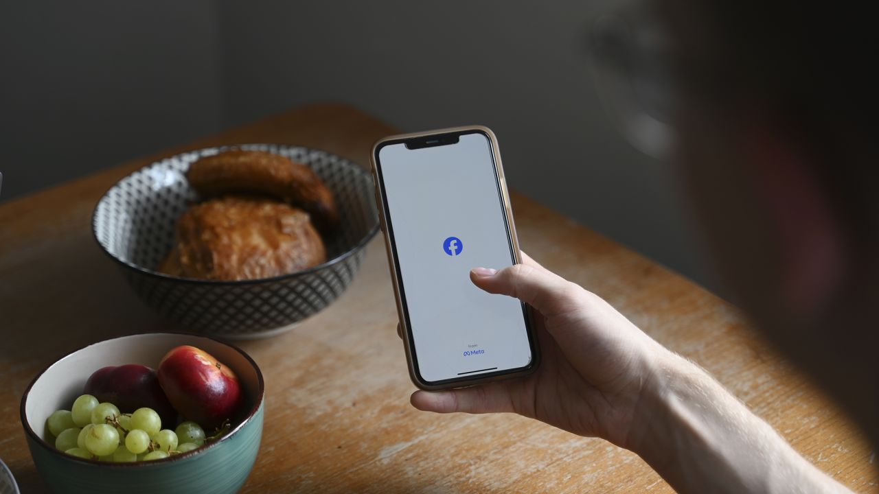 A man opens the social media app Facebook on his smartphone.