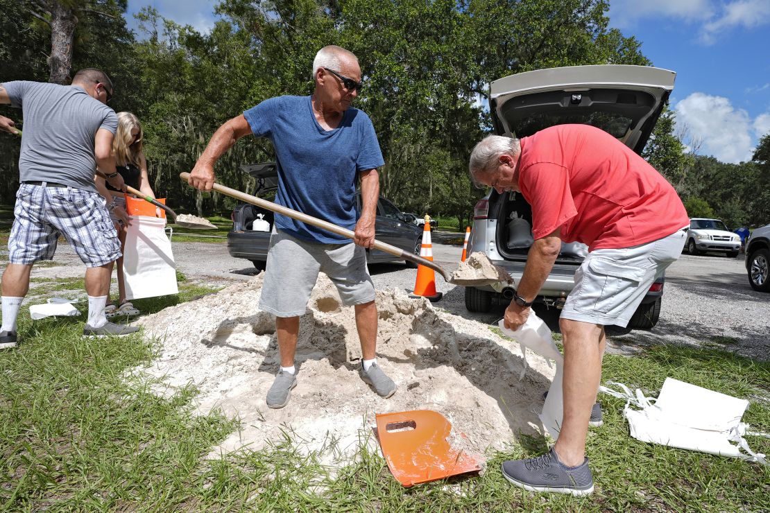 Roger Heim, right, and Terry Smith, center, both of Valrico, Florida, fill sand bags at Edward Medard Conservation Park in Plant City.