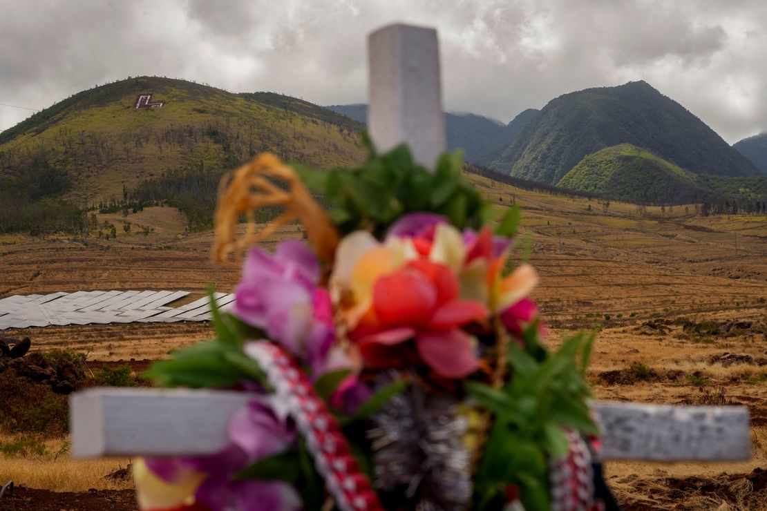 A lei-adorned cross honors wildfire victims in Lahaina, Hawaii.