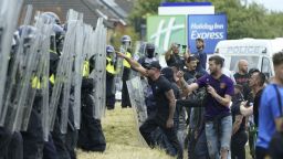 Police officers with protesters as trouble flares during an anti-immigration demonstration outside the Holiday Inn Express in Rotherham, South Yorkshire. Picture date: Sunday August 4, 2024. 77057462 (Press Association via AP Images)