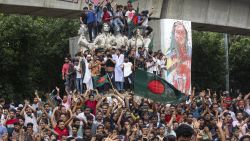 Protesters climb a public monument as they celebrate after getting the news of Prime Minister Sheikh Hasina's resignation, in Dhaka, Bangladesh, Monday, Aug. 5, 2024. (AP Photo/Rajib Dhar)