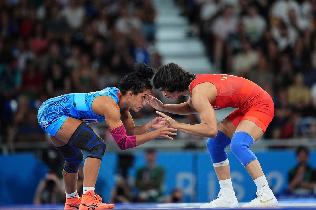 India's Vinesh Phogat (red) takes on Cuba's Yusneylis Guzman Lopez during the Olympic women's freestyle 50kg wrestling semifinal at the Champ de Mars Arena on August 6, 2024 in Paris.