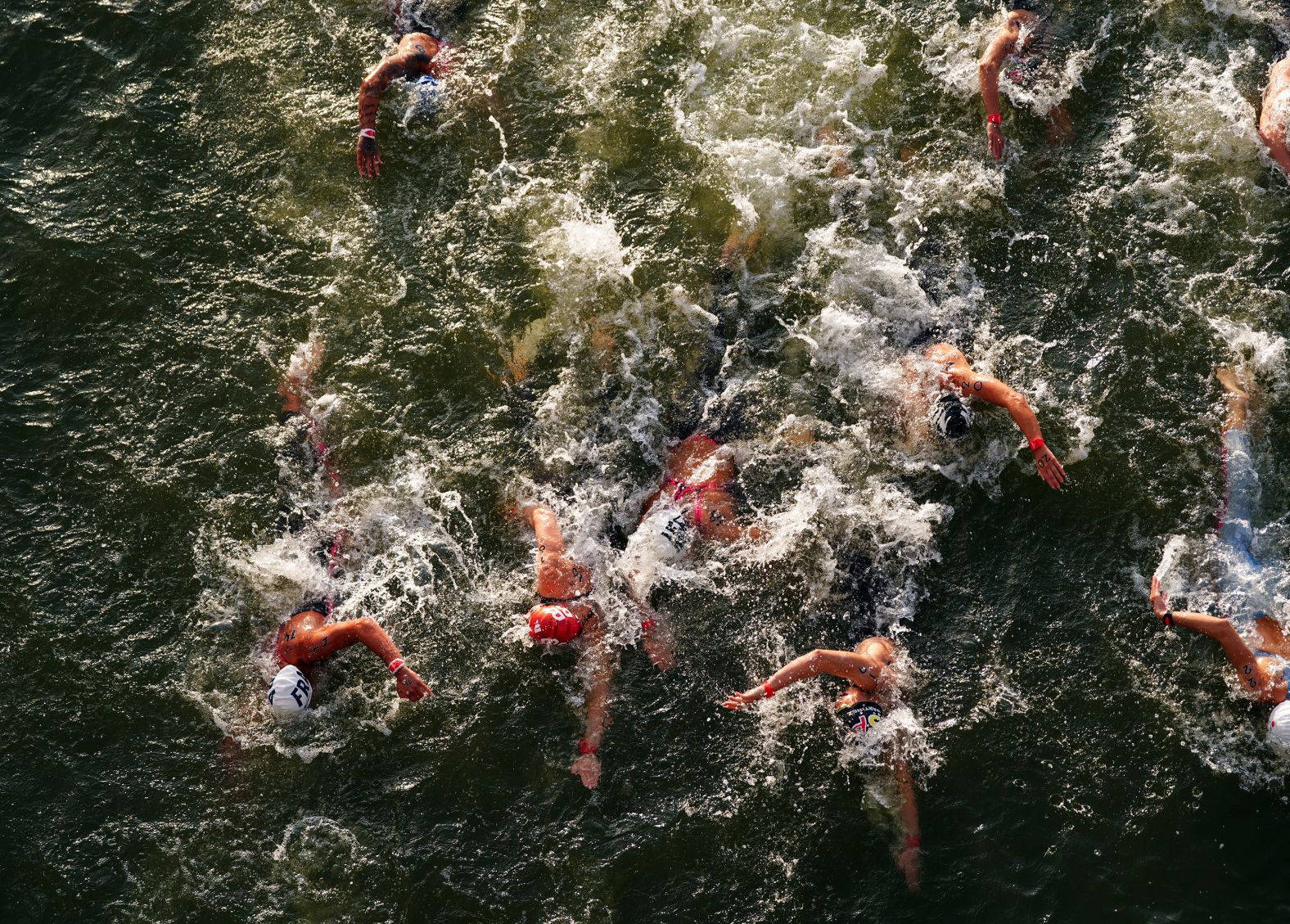 Competitors swim in the Seine River during the women's 10-kilometer marathon on August 8. The water quality of the river has been an?<a >ongoing saga</a> at the Games, but organizers deemed it fit for athletes to race in.