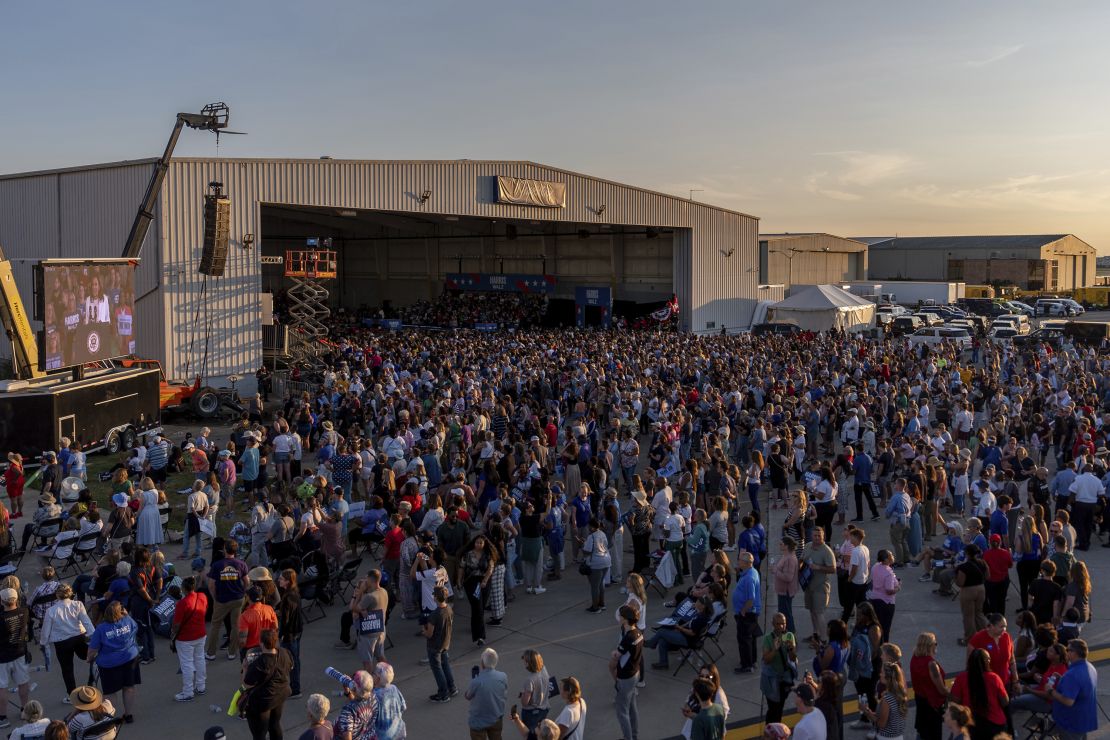 People listen to Harris speak at Detroit Metropolitan Wayne County Airport on August 7, 2024, in Romulus, Michigan, where screens were set up for those who couldn't see the stage.