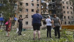 Residents of an apartment building damaged after shelling by the Ukrainian side stand near the building in Kursk, Russia, Sunday, Aug. 11, 2024. (AP Photo)